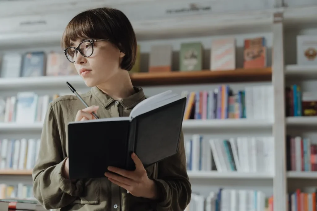 Seseorang mempertimbangkan buku sebelum membelinya di toko buku