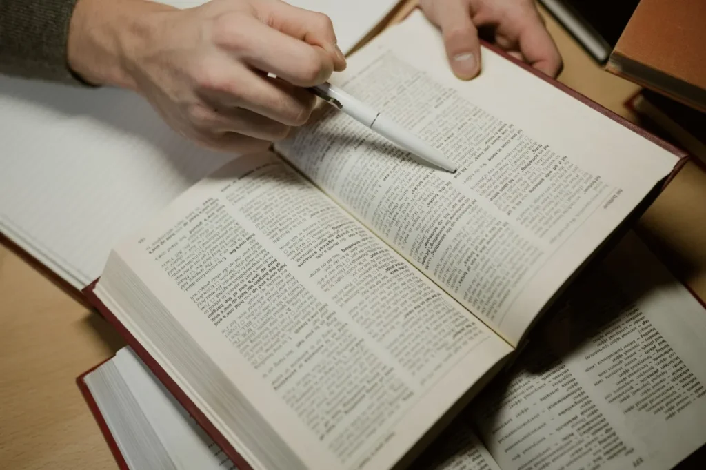 Buku terbuka dengan penanda halaman dan pensil di atas meja untuk membaca terarah