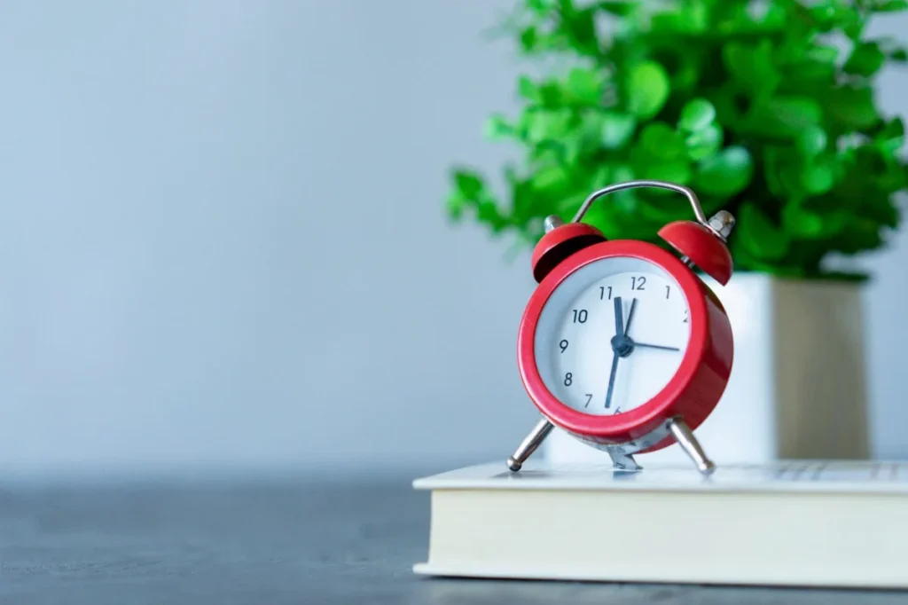 Buku, timer, dan segelas air untuk memulai sesi membaca singkat
