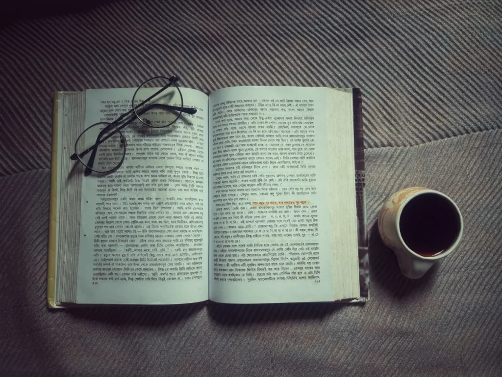 Pembaca mendalami satu buku dengan buku catatan di sampingnya