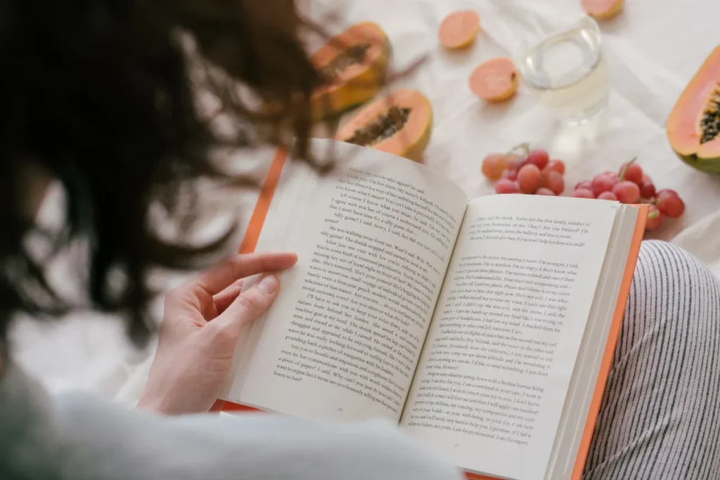 Anak muda membaca buku di dekat jendela pada pagi yang tenang