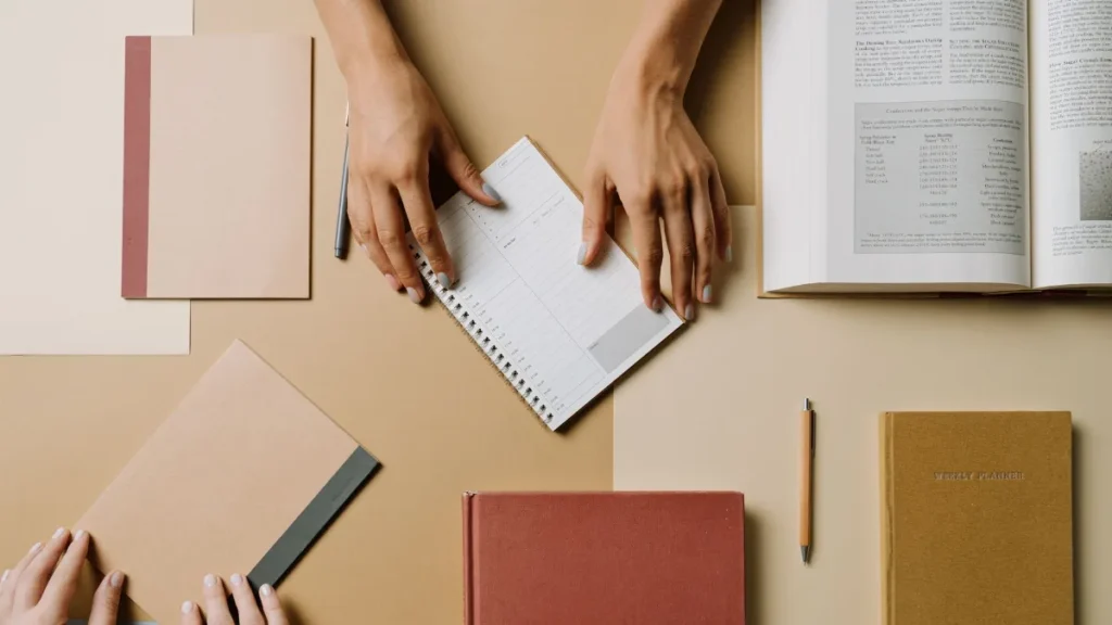 Jurnal, pena, dan buku terbuka untuk mencatat pola kebiasaan membaca